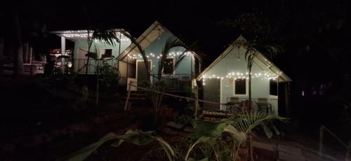 un paio di case con le luci accese di notte di Green Garden Resort a Canacona