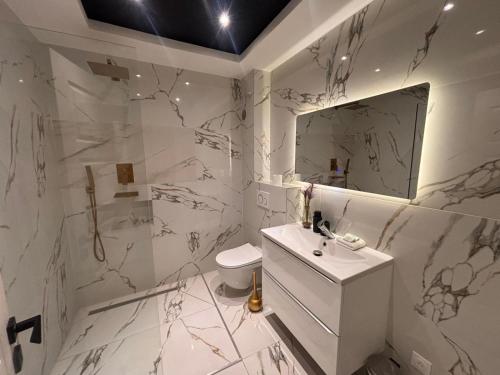 ein weißes Badezimmer mit Waschbecken und Spiegel in der Unterkunft Appartement T3 in Frontenex-Villard-Rosset