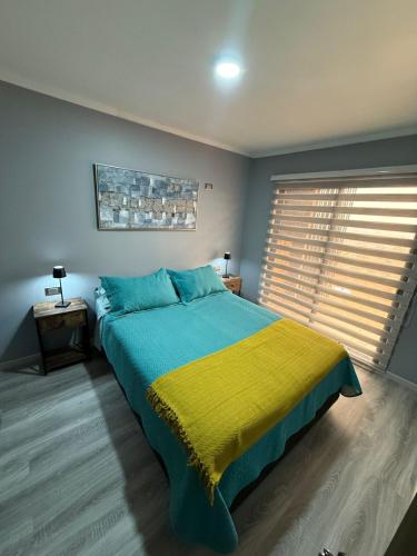a bedroom with a large bed with a yellow blanket at Cabañas Bello Atardecer in Constitución