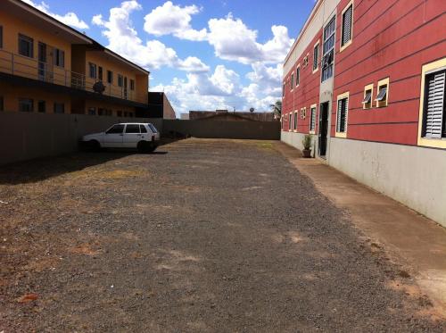 um carro estacionado em um estacionamento próximo a um prédio em Apart Cavalari Kitnets em Marília