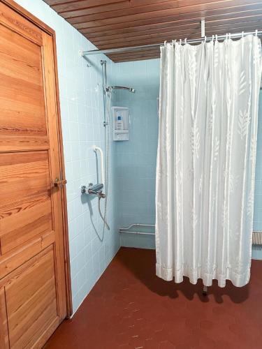 Una ducha con cortina blanca en un baño. en House in Finnish Lapland, en Kemijärvi