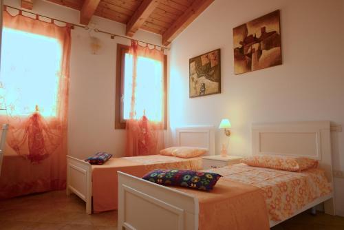 1 dormitorio con 2 camas y ventana en Agriturismo Dartora en Sambruson