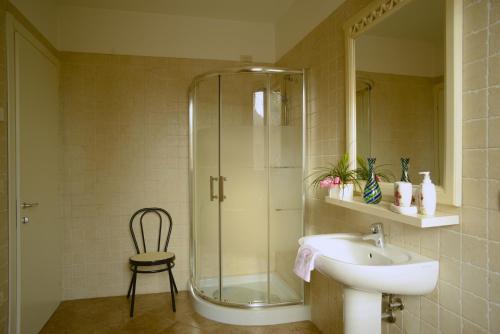 uma casa de banho com uma cabina de duche em vidro e um lavatório. em Agriturismo Dartora em Sambruson
