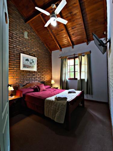 a bedroom with a red bed and a ceiling fan at Altos del Rincón in Merlo