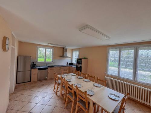 una cucina con un lungo tavolo e sedie di Domaine Muleterie a Chavagnes-les-Redoux