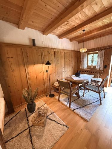 a dining room with a table and chairs and wooden walls at Ferienwohnung Eggerhof-Schaller in Innervillgraten