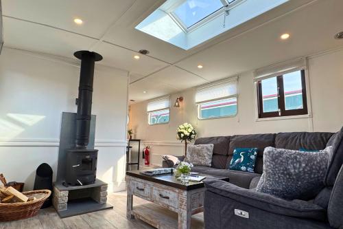 a living room with a couch and a stove at The Swan Flotel - Barton Marina in Burton upon Trent