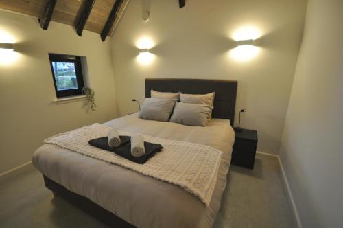 a bedroom with a bed with two shoes on it at Hoeve 't Peerdeke in Breda