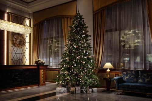 a christmas tree in a room with a couch and a chair at Art Deco Imperial Hotel in Prague