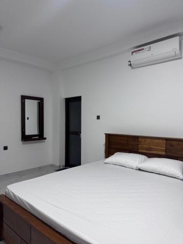 a bedroom with a large bed with a white mattress at Hirudee Villa in Unawatuna
