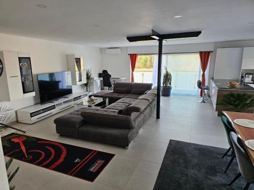 un soggiorno con divano e TV a schermo piatto di Sebastian's Chalet Royal a Ötigheim