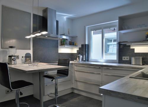 a kitchen with a counter and some chairs in it at Altstadtrefugium Krämerbrücke in Erfurt