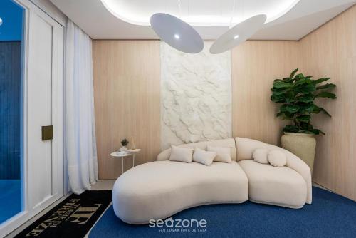 a room with a white ottoman in a room at Apto c/ Churrasqueira a 500m da Praia TDF0302 in Itapema