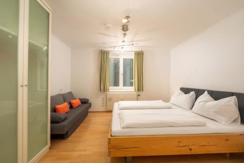 a bedroom with a large bed and a couch at Appartement Dachsteingasse by Schladming-Appartements in Schladming