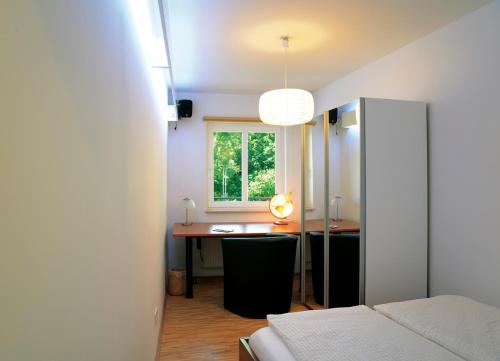 um quarto com uma secretária, uma cama e uma janela em Altstadtrefugium Krämerbrücke em Erfurt