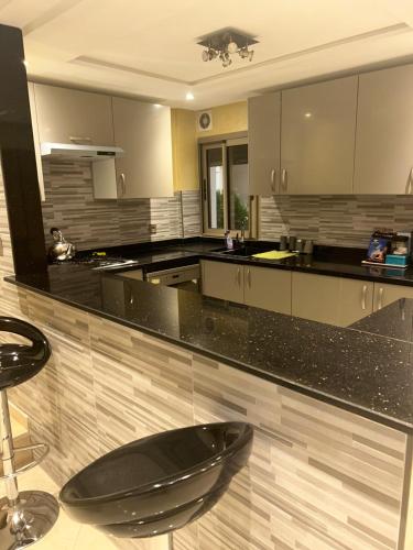 阿加迪尔Appartement Premium à Agadir Calme, Clim,Plage à 5 min的厨房配有黑色台面和黑色座椅。