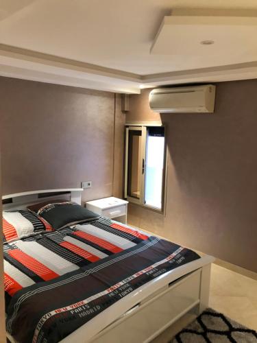 阿加迪尔Appartement Premium à Agadir Calme, Clim,Plage à 5 min的一间带床的卧室，位于一间有窗户的房间里