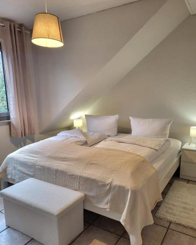 a white bed in a room with at Weltmann`s Hotel & Restaurant in Ennepetal
