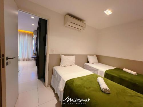 a bedroom with two beds and a door to a room at Holandas Prime Tambaú in João Pessoa