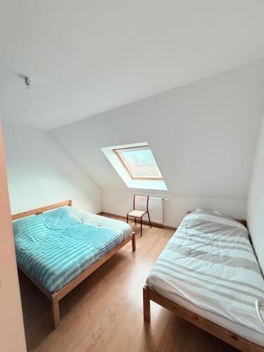 a bedroom with two beds and a skylight at MAISON SERENITY Bohars in Bohars