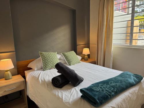 a bedroom with a bed with two pillows on it at Outspan Lodge in Fish hoek