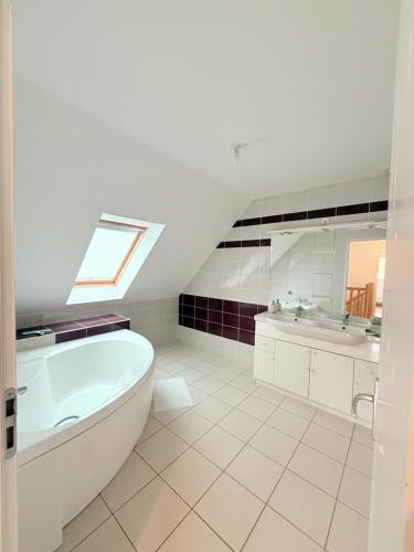 a white bathroom with a tub and a sink at MAISON SERENITY Bohars in Bohars