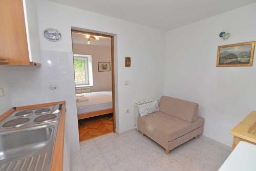 a kitchen with a chair next to a stove at Studio Veli A in Veli Lošinj