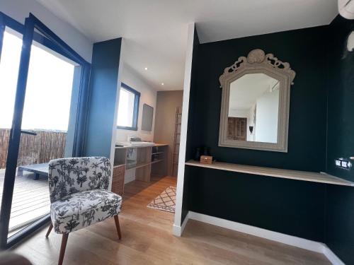 a living room with a mirror and a chair at Villa Nomade proche de Cannes in Vallauris