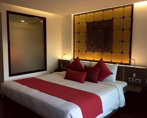 Beautiful Pool View Studio in Kata في شاطئ كاتا: غرفة نوم بسرير أبيض كبير مع وسائد حمراء