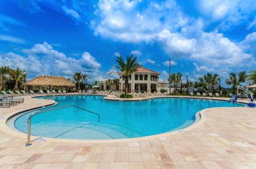 a swimming pool at a resort with palm trees at Renewed Luxury Townhouse with private pool in Kissimmee