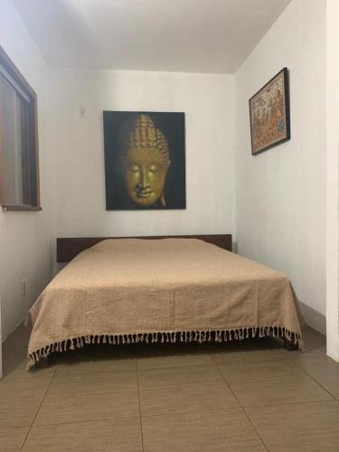 a bedroom with a bed with a mask on the wall at Jasmim Manga in Marau