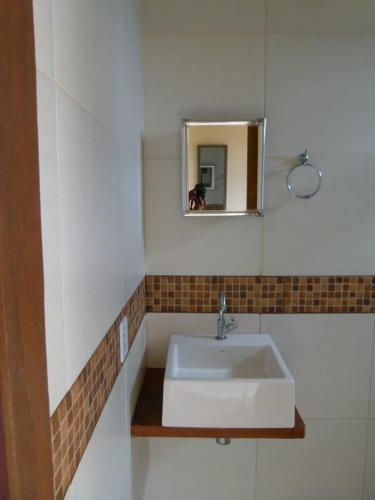 a bathroom with a white sink and a mirror at Jasmim Manga in Marau