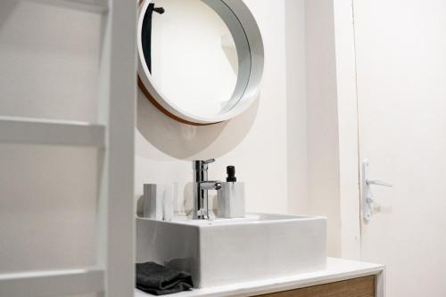 a bathroom with a white sink and a mirror at Maisonnette aéroport Orly in Paray-Vieille-Poste