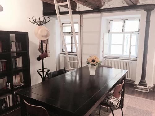 uma mesa de jantar preta com um vaso de flores em Casa Livia em Lindau