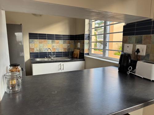 a kitchen with a counter top and a sink at Outspan Lodge in Fish Hoek