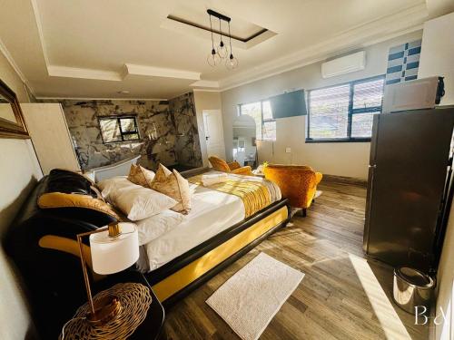 Starlight Inn Boutique Hotel في Humewood: غرفة نوم بها سرير كبير وأريكة
