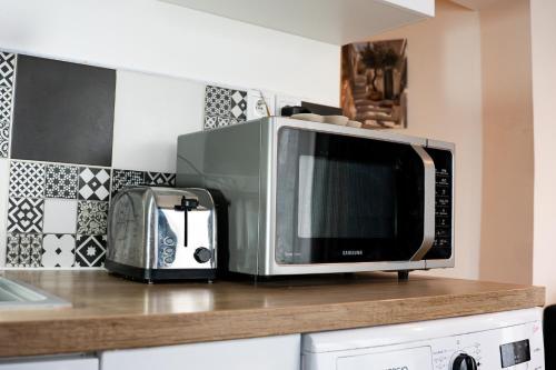 a microwave sitting on top of a kitchen counter at Maisonnette aéroport Orly in Paray-Vieille-Poste