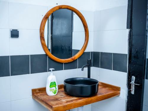 Appartement Cosy avec Balcon - Haie Vive في كوتونو: حوض حمام مع وعاء أسود ومرآة