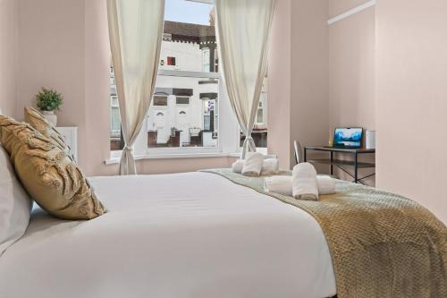 a bedroom with a large white bed with a window at Contractors, Free Parking, TV, Discounts, Wi-Fi in Wallasey