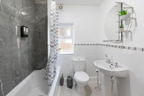 a white bathroom with a toilet and a sink at Contractors, Free Parking, TV, Discounts, Wi-Fi in Wallasey