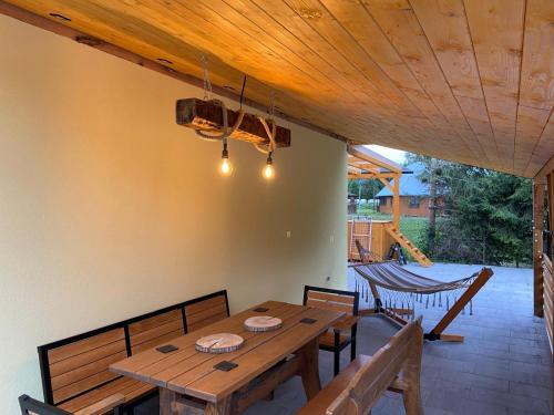 a dining room with a wooden table and chairs at Apartament na lipowej in Pastwiska