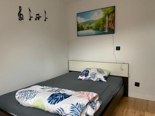 a bed with two pillows on it in a room at Apartament na lipowej in Pastwiska