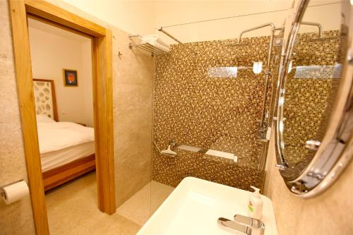 a bathroom with a shower with a sink and a mirror at Villa Fora Hvar in Hvar