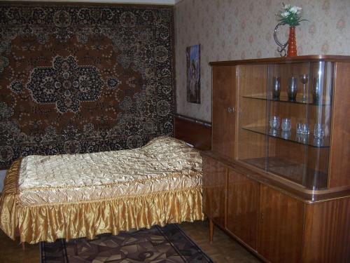 ヤロスラヴリにあるApartment Pisemskogo 46のベッド1台、木製ドレッサー(棚付)が備わる客室です。