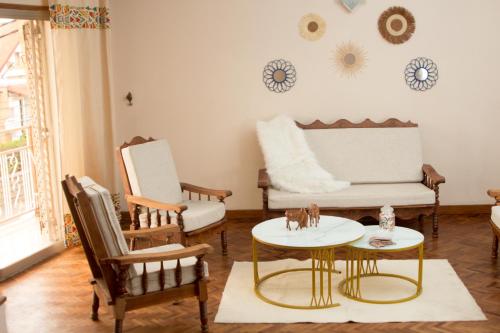 a living room with a couch and chairs and a table at COCOONING HOME # Centre-Ville # Confort # Charmant # マダガスカルのゲストハウス in Antananarivo