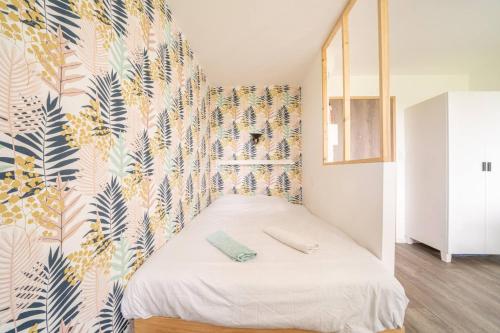 Schlafzimmer mit einem Bett mit Wandbild in der Unterkunft Les studios de l'Albatros in Saint-Nazaire