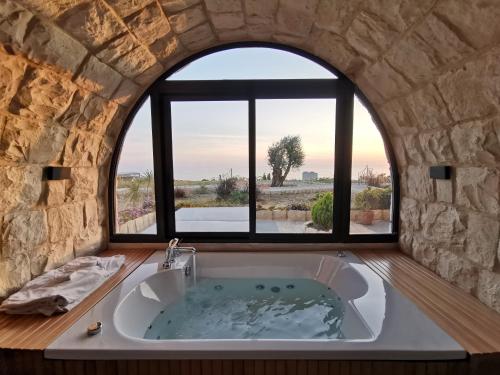 a large bath tub in a room with a window at Casa de Thoum in Batroûn