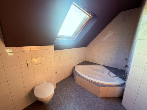a bathroom with a toilet and a sink and a window at FeWo 5Z Terasse 2 Bad in Lingen