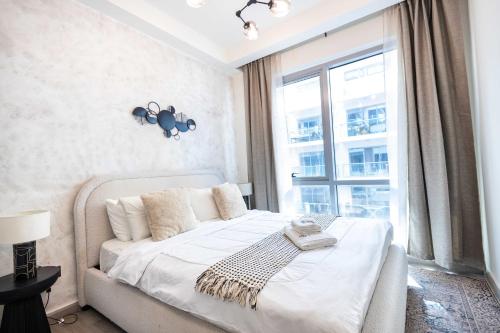 a bedroom with a bed and a large window at Island Vista Haven 2 BR Private beach I Rooftop Pool in Ras al Khaimah
