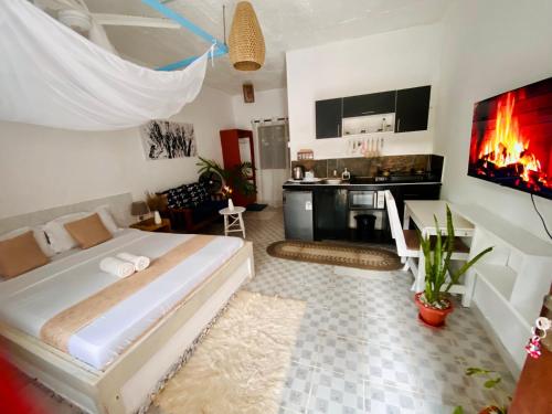 een slaapkamer met een groot bed en een keuken bij Elala Studio Homes in Diani Beach